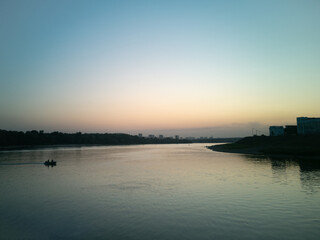 A boat with people sailing on the sea at sunset