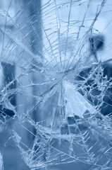 Accident - close-up of broken window. Detail of rifts of cracked glass. Blue background