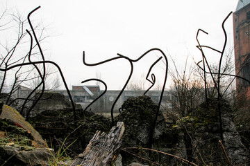 The rebar sticking up from piles of brick rubble, stone and concrete rubble against the sky in a...