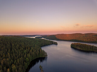 Aerial landscape with sunset by lake and forests