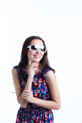 Happy brunette woman in sunglasses and colorful dress, isolated.