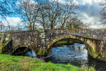 Fototapeta premium A view across the Gelli bridge, an eighteenth century, grade 2 listed bridge that spans the River Syfynwy, Wales