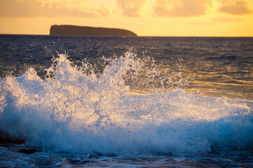 Molikini crater seen from Maui as waves crash on the rocks of Makena beach. © Marcos