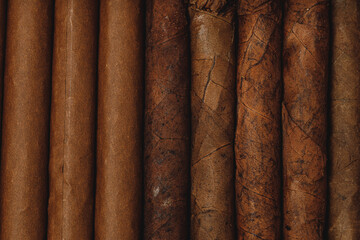 Background of stacked rolled cigars close up
