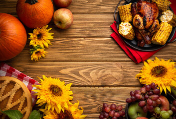 Thanksgiving festive table composition with roasted turkey, pumpkin pie, autumn fruit. Thanksgiving celebration dinner with traditional fall meals on rustic wooden table. Space for text, from above.