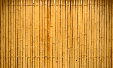 background and texture of decorative yellow bamboo wood on finishing wall surface.