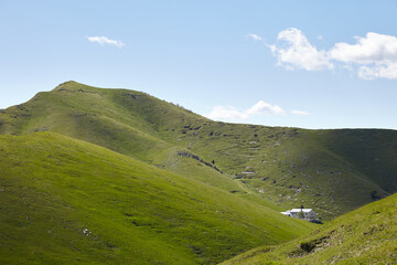 Fototapeta na wymiar Mountain hut in green valley