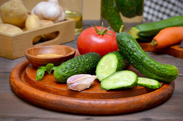 still life with fresh vegetables on the kitchen table cucumbers and tomatoes and garlic and basil and potatoes