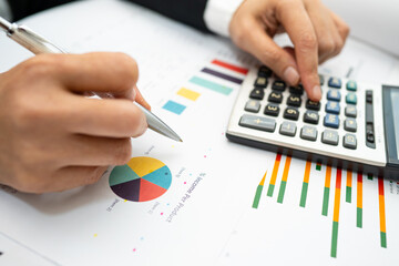 Asian accountant working and analyzing financial reports project accounting with chart graph and...