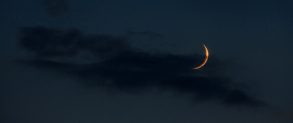 young moon on a dark night sky copy space banner © dvulikaia