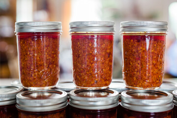 Jars of Thai Chili Paste / Chili Sauce on a kitchen counter. This spicy chili jam is called chili oil, or Naam Prik Phao and Vietnamese Lemongrass Chili Garlic Sate (