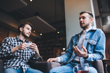 Young modern men talking together while drinking in cafe - Powered by Adobe