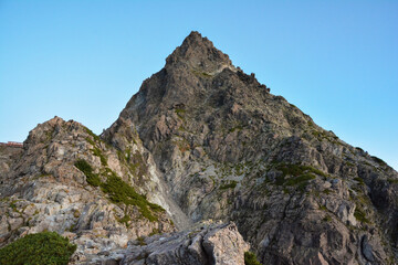 夏の早朝、夜明けを迎えた槍ヶ岳の山頂。