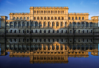 Kaliningrad art Museum building on sunrise reflected in the river still water. Blue sky, high contrast.