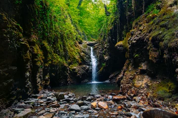 Fototapeten atemberaubende landschaft mit einem bergwasserfall, wasserfluss bei langer belichtung © dvulikaia