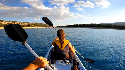 Woman kayaking in beautiful landscape at Embalse de la Bolera, Spain.