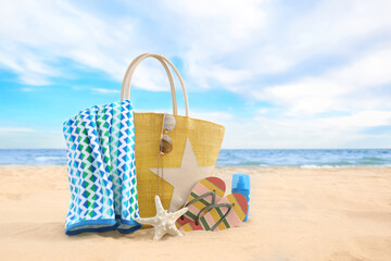 Different stylish beach objects and starfish on sand near sea