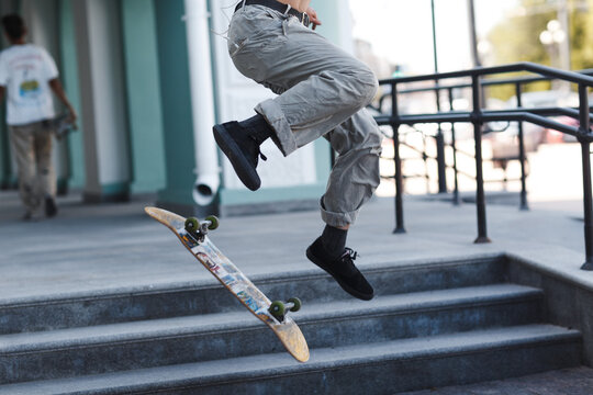 Young boy riding trick on skateboard in city