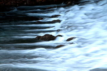 River cascade, waterfall with black rocks