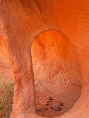 Ein orangefarbener Felsen mit einem ovalen Loch
