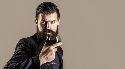 Man holding glass of champagne in hand. Beard man, bearded, sommelier tasting red wine. Sommelier,...