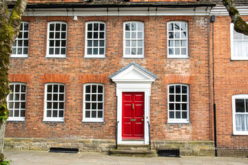 English house with red bricks, white windows and red door, England