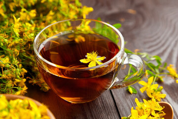 Hypericum perforatum, St Johns wort or tutsan plant drink with fresh flowers.