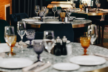 tableware Glasses, flower fork, knife served for dinner in restaurant with cozy interior