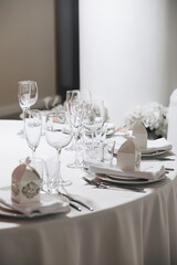 tableware Glasses, flower fork, knife served for dinner in restaurant with cozy interior