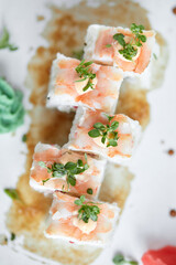 Japanese cuisine, fresh sushi on a light background. Assorted sushi with wasabi, soy sauce and ginger