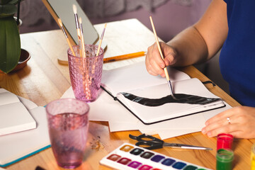 Woman os drawing a picture with watercolors
