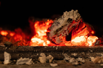 Firewood stove with bricks, highlighting the ember. Black orange color and embers in the center of the image
