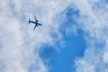 Plane in a blue sky with clouds, view from below