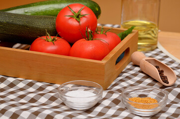 fresh vegetables in a basket still life with tomatoes and zucchini and condiments on the table 