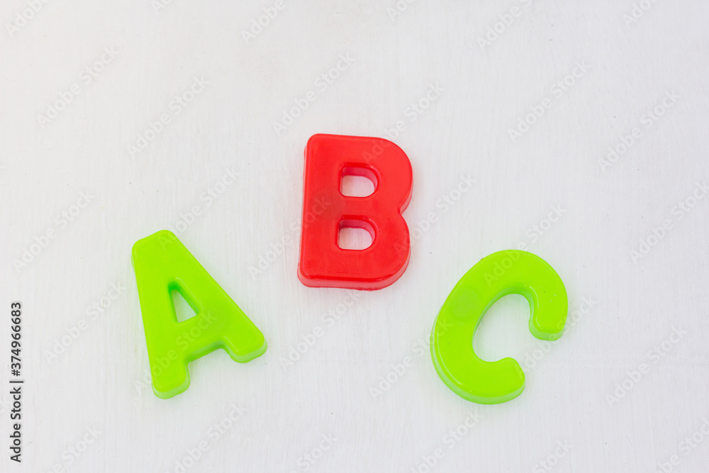 Wall mural letters abc on white background. learning alphabet with plastic toy, english language school