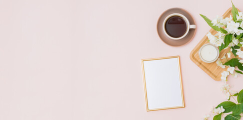 Mockup gold frame with a cup of coffee and jasmine flowers on a color background