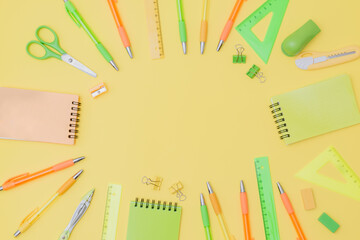 Flat lay composition with school supplies on a yellow background