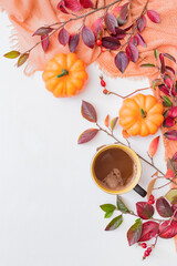 Flat lay composition with colorful autumn leaves, scarf and a cup of coffee on a white background