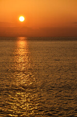 Sun going down at sea with a beautiful orange and warm tone