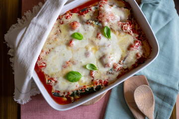 Zucchini Parmesan with mozzarella on top in a tray, out of the oven, ready for lunch, shot from...
