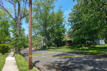 Electric line hanging down from a utility pole and onto a small neighborhood street