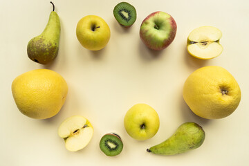 A variety of colourful fresh fruit on a yellow background shot from above with copy space