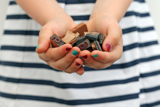 Close-up of a girl's hands holding typographic characters