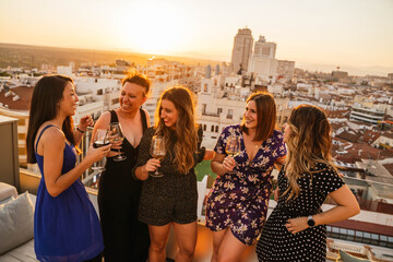 Groupe de jeunes amis buvant du vin pendant le coucher du soleil à Madrid