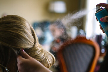 wedding hairdresser at work, doing the hair, uses hairspray