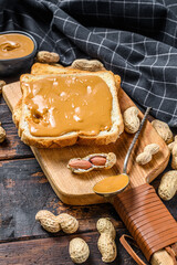 Crispy toast with peanut butter on breakfast.  Dark Wooden background. Top view