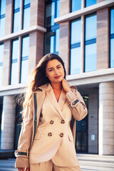 young pretty brunette woman in fashion suit at business building posing cheerful, lifestyle people concept