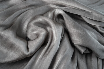 Background from a gray flowing glossy silk fabric. Fabric texture.