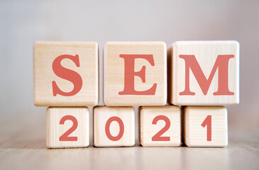 SEM 2021 text on wooden cubes on a monochrome background with reflection.