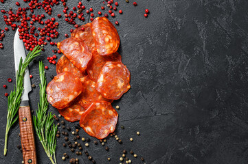 Spanish sliced chorizo sausage. cured meat. Black background. Top view. Copy space